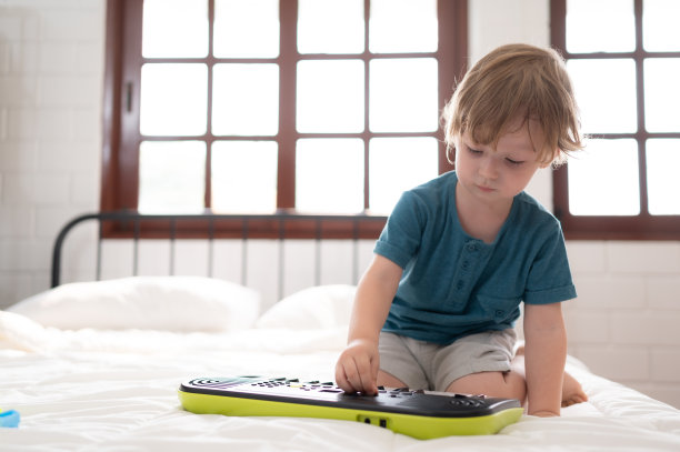 小男孩在他的卧室里，拿着他父母买的新玩具，帮助他提高思考能力。图片下载