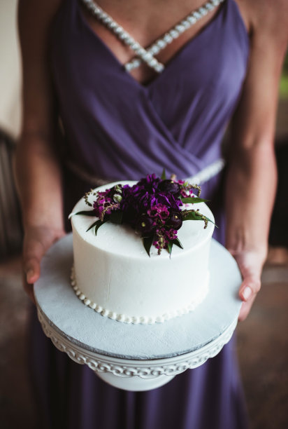 身穿紫色礼服的伴娘手持结婚蛋糕图片下载