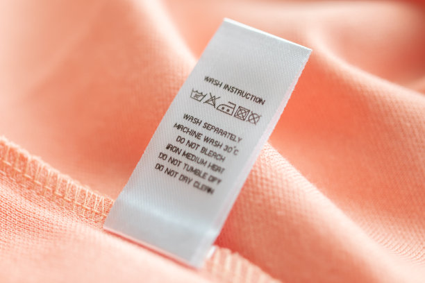 白色洗衣护理洗涤说明衣服标签上的粉红色棉衬衫图片下载