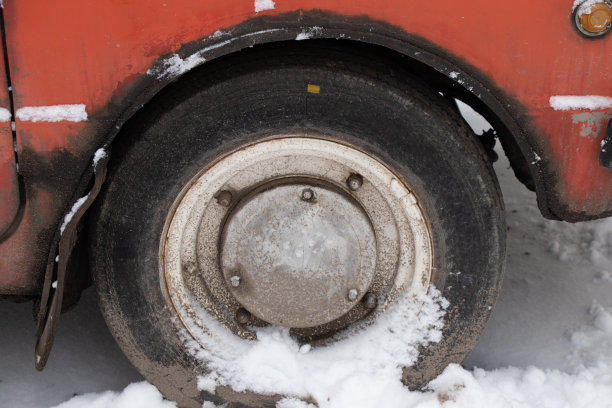 旧汽车车轮在雪地上的道路在冬天特写图片下载