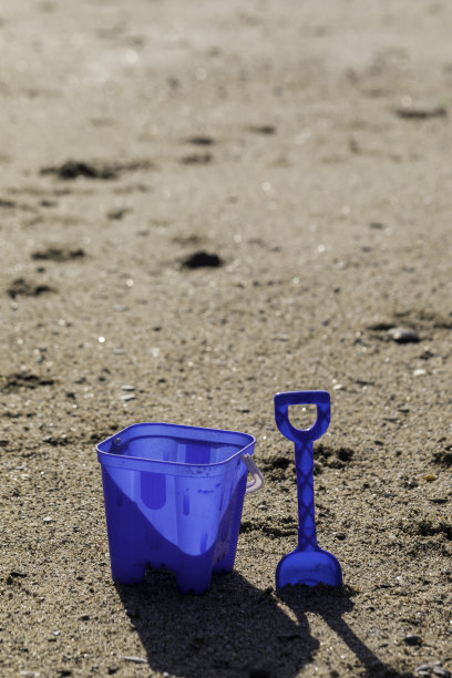 沙滩上有一个水桶和铁锹图片下载