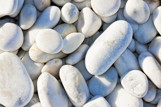 白色和灰色的石头被海水冲刷成柔和的圆形图片下载