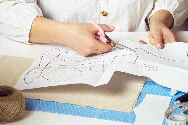 手工制作的自己动手教程。裁剪过的女裁缝手从纸上剪出不同形状、图案图片下载