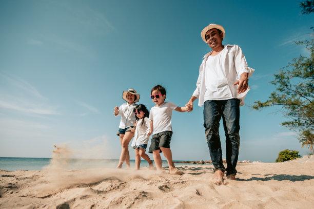 亚洲家庭在海滩度假与家庭关系。假日，夏日和假期的沙滩快乐家庭旅行概念。图片下载