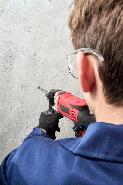 有人用钻头在墙上钻了个洞，垂直射击图片下载