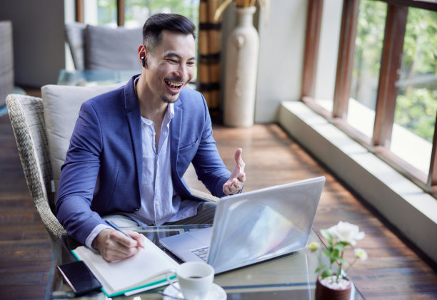 年轻英俊的亚洲商人使用笔记本电脑进行视频通话，坐在咖啡馆或联合办公空间。电话会议或在线工作图片下载