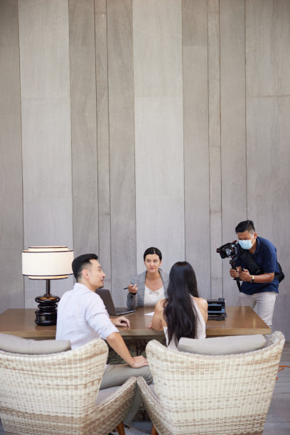 专业的男性摄影师拍摄商业或与房地产中介的咨询会议。在摄影行业的幕后。拍摄库存摄影内容图片下载