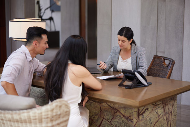 年轻的亚洲夫妇与银行家或咨询代理人交谈，进行法律交易，贷款或抵押贷款，购买房地产，新公寓或房子图片下载