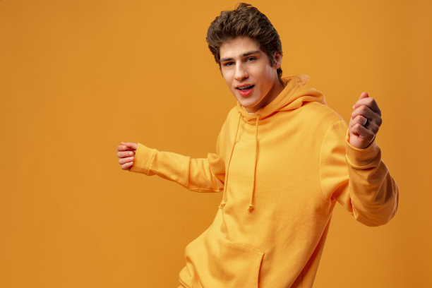 年轻开朗的人跳舞有乐趣在黄色的背景图片下载