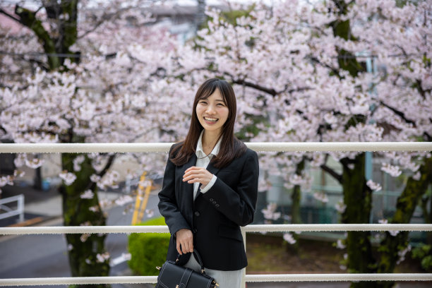 年轻的女商人站在樱花前的肖像图片下载