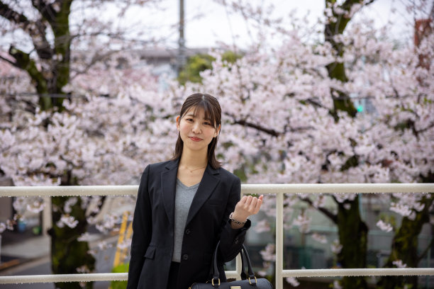年轻的女商人站在樱花前的肖像图片下载