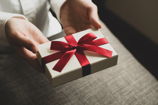 女性手拿红丝带的礼盒图片下载