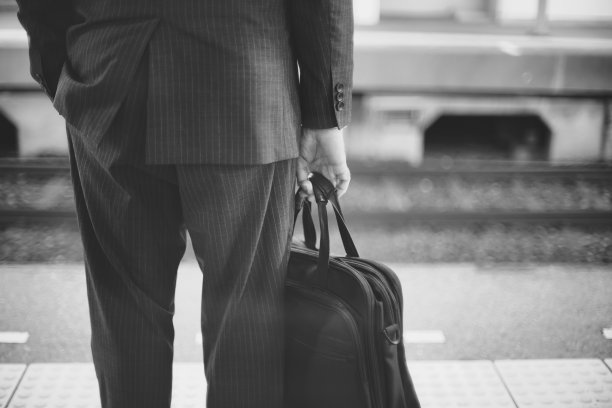 一个拿着商务包的男人的灰度图图片下载