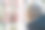 一名身穿夹克、头戴围巾的年轻金发女子在一家眼镜店为自己挑选眼镜。图片下载