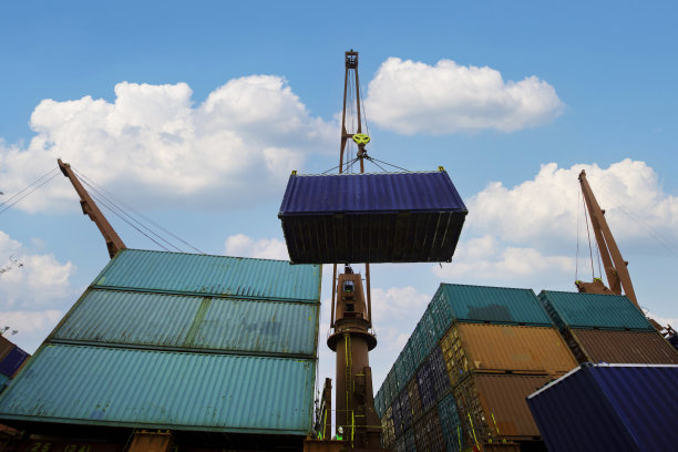 工业起重机在货船上装载集装箱，日出时分的物流港口图片下载
