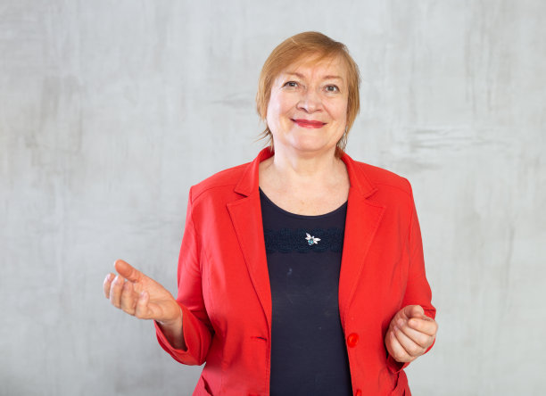 积极的高级红发女商人在红色外套在工作室摆姿势图片下载