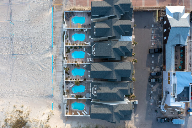 海滩住宅的鸟瞰图，每个都有一个沙滩上的游泳池图片下载