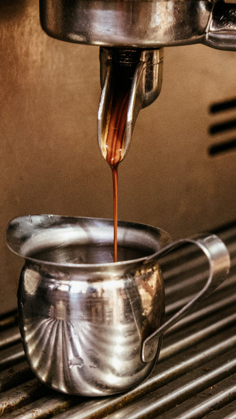 咖啡从咖啡机中倒入金属罐中图片下载