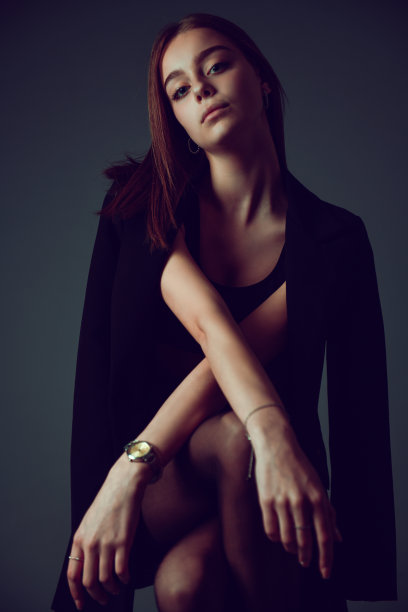 穿着得体的优雅女性在灰色背景前展示虚荣图片下载