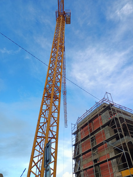 在一座多层建筑附近的大型施工现场，一台起重机正在工作图片下载