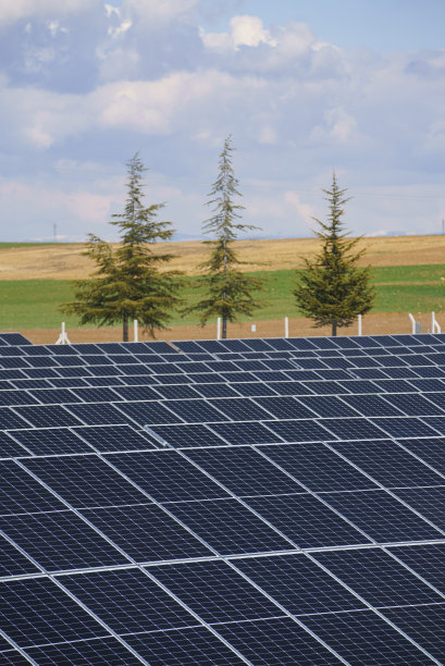 场地上的太阳能电池板，背景是多云的日落天空图片下载