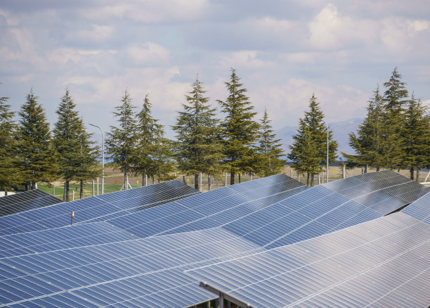 场地上的太阳能电池板，背景是多云的日落天空图片下载