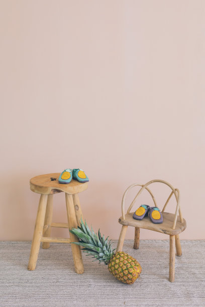 宝宝在菠萝附近的椅子上穿鞋图片下载