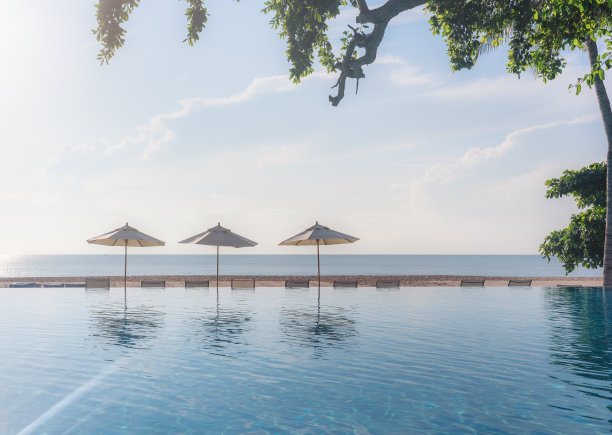 夏天的海滩，夕阳下的游泳池，海滩背景。暑假图片下载