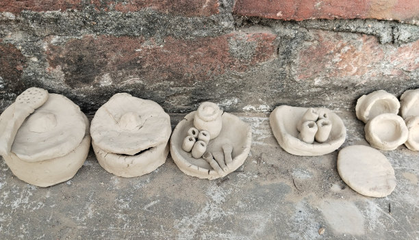 孩子们玩的手工粘土玩具。用地板上的泥土制成的印度厨房小玩具容器。孩子用粘土做盘子和各种各样的人物。陶器的技能。爱好和兴趣。图片下载