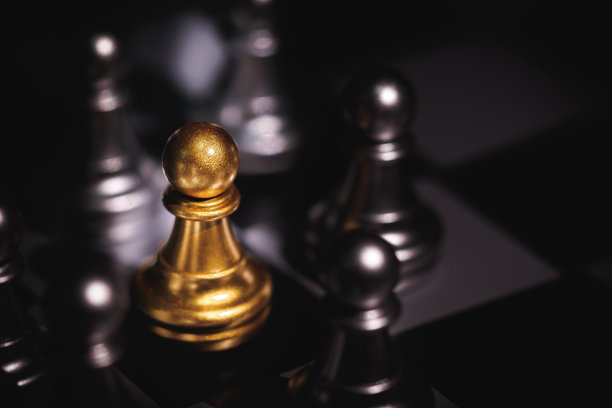 金色棋子被银色棋子包围。图片下载