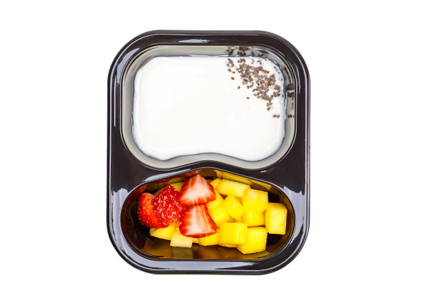 一份酸奶甜点，草莓和芒果在一个塑料碗。从上面看。图片下载