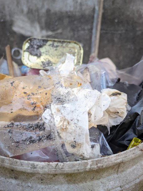 垃圾中堆积着各种垃圾，塑料垃圾、用过的纸巾、烟头和烟灰、食品罐等有机垃圾图片下载