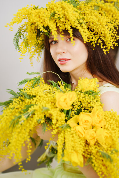 美丽温柔的年轻女子黑发花束和含羞草花环图片下载