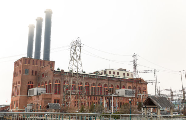 一座废弃的老砖厂大楼高高耸立，破碎的窗户和杂草丛生，展示了过去时代的工业遗产图片下载