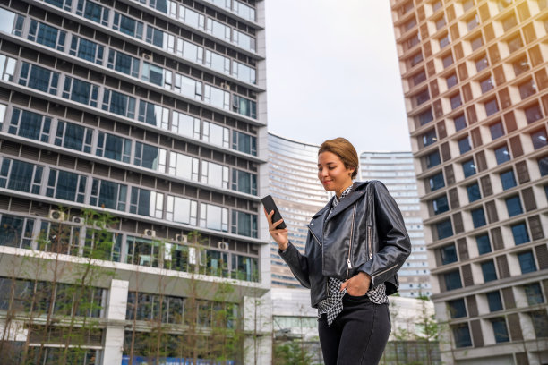 在城市中边走边用智能手机发短信的女人图片下载