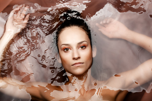 水下美丽的肖像一个美丽的白人女孩。看着镜头。红色的水…图片下载