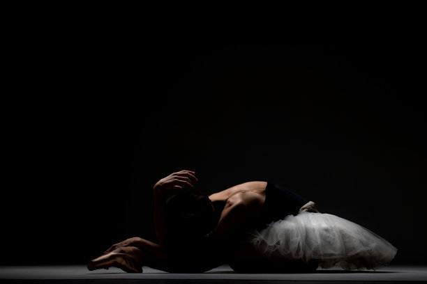 芭蕾舞女演员穿着芭蕾舞裙在地板上摆姿势图片下载