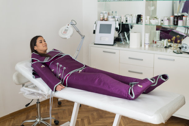 一个女人在美容诊所做加压治疗。库存图片图片下载