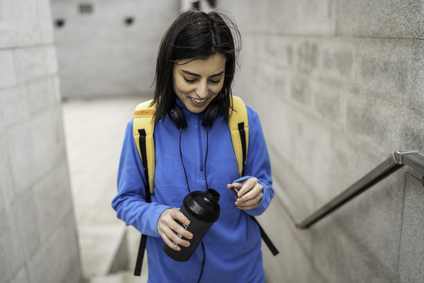 年轻女子在户外运动后喝水图片下载
