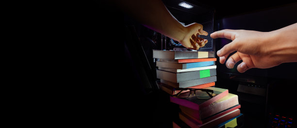 手抓着黑底电脑里的书，技术和知识的概念。图片下载
