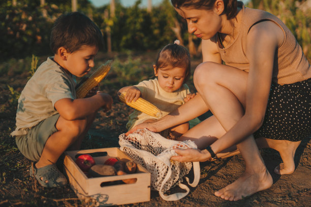 在农场工作的家庭为可持续发展，农业和农耕生活方式在一起。快乐，微笑和一个女孩和一个男孩的肖像，他们的母亲和一盒蔬菜在大自然中图片下载