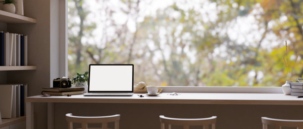 最小舒适的工作空间，笔记本电脑放在靠窗的木桌上，可以欣赏自然景观图片下载