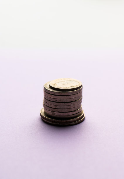紫色背景上的一堆硬币。图片下载