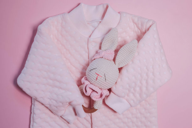 粉色背景上的粉色女孩连身裤。新生儿的春装图片下载