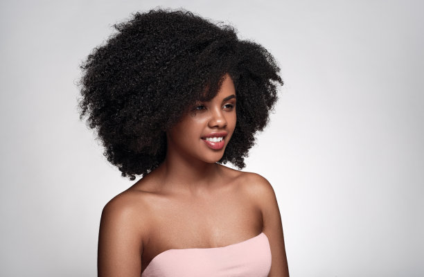 高兴的年轻黑人妇女微笑着看向灰色的工作室图片下载