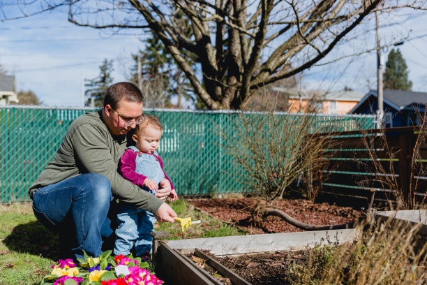 慈爱的父亲和他的小女儿在前院享受春天图片下载