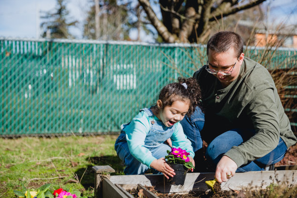 慈爱的父亲和他的小女儿在前院享受春天图片下载