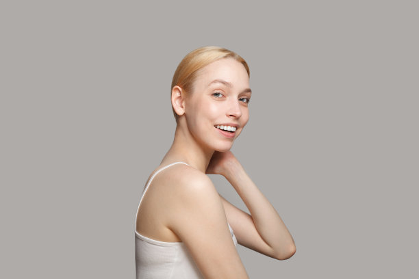 肖像的女人金发站在侧面孤立的灰色背景。美容、化妆品、护肤、魅力图片下载