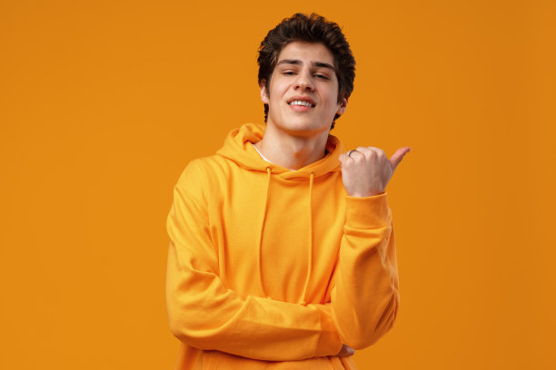 年轻英俊的男子在蓝色的背景指向一边图片下载