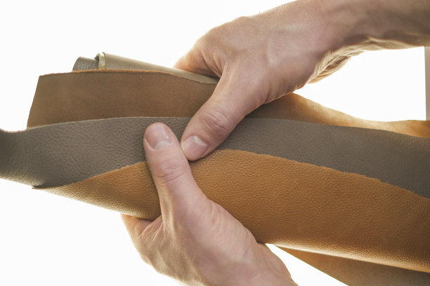 皮革材料。真皮品种。真皮件设置在男性手中的白色背景。图片下载